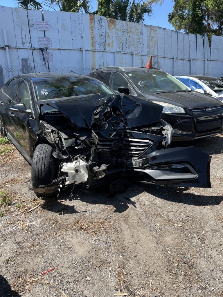 Wrecked Car. Daughter in Hospital Bed. Nicole's car very crunched after the accident. Her car is black and you can see the right tired is hanging off to the side. The cabin where the drivers seat was though looks in tact, like there were angels in the car with her protecting her.