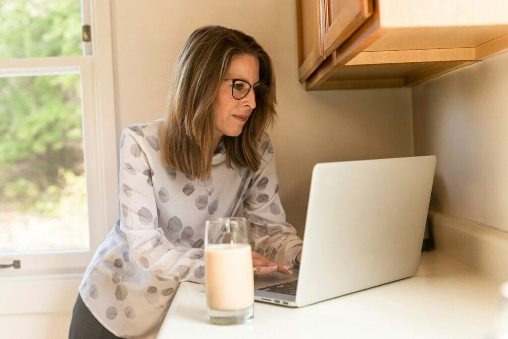 What is content creation? woman using her MacBook Pro inside white room staring at the screen.