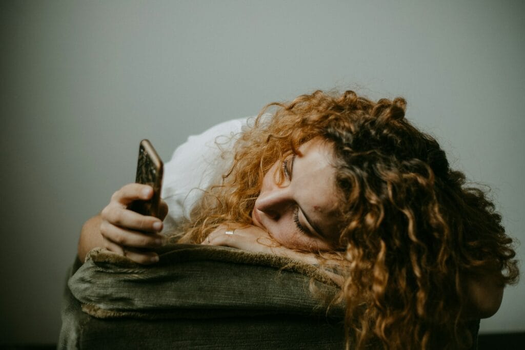 is pinterest social media? woman in gray sweater holding smartphone