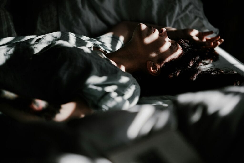 no one is too busy. a person laying in bed with their head on a pillow