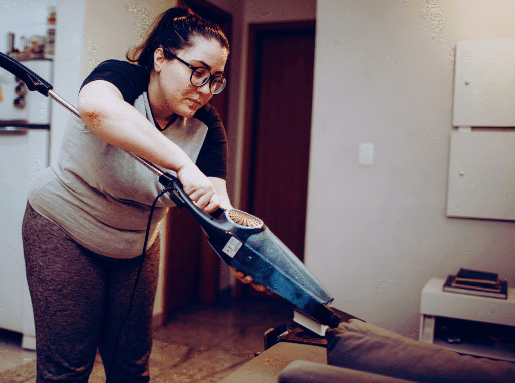 How long does it take for pins to appear on pinterest. woman with glasses and a vacuum cleaner cleaning her house.