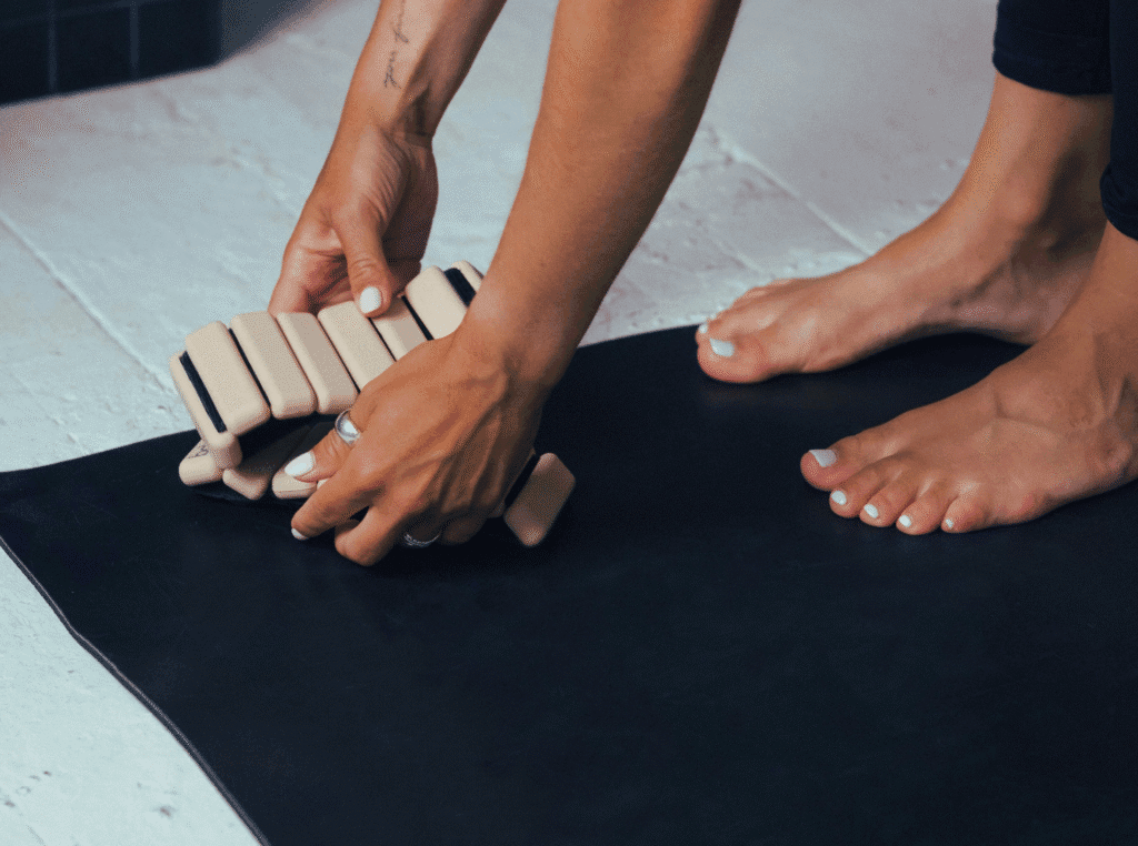 how does grounding work. woman standing on a grounding mat with her bare feet and doing something with her hands and blocks maybe.