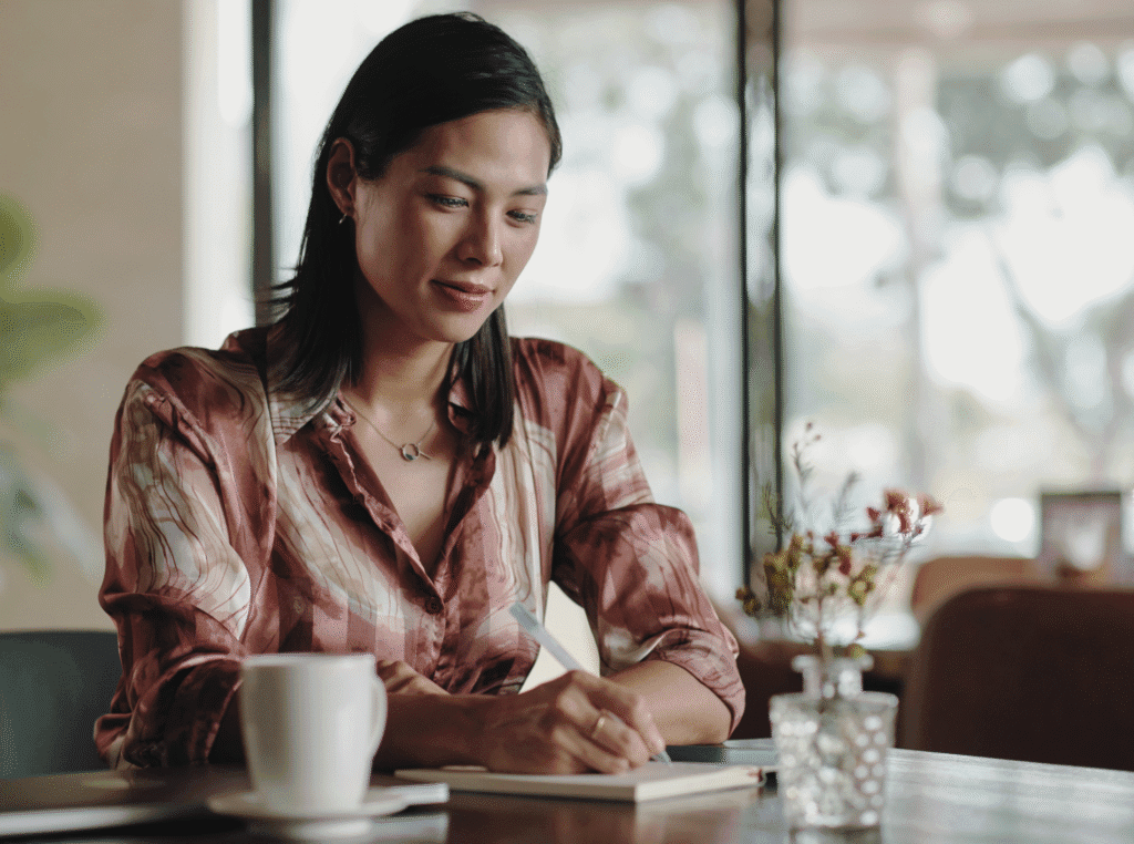 Good Values And Morals. tired woman sitting at the table with a pen and paper writing.