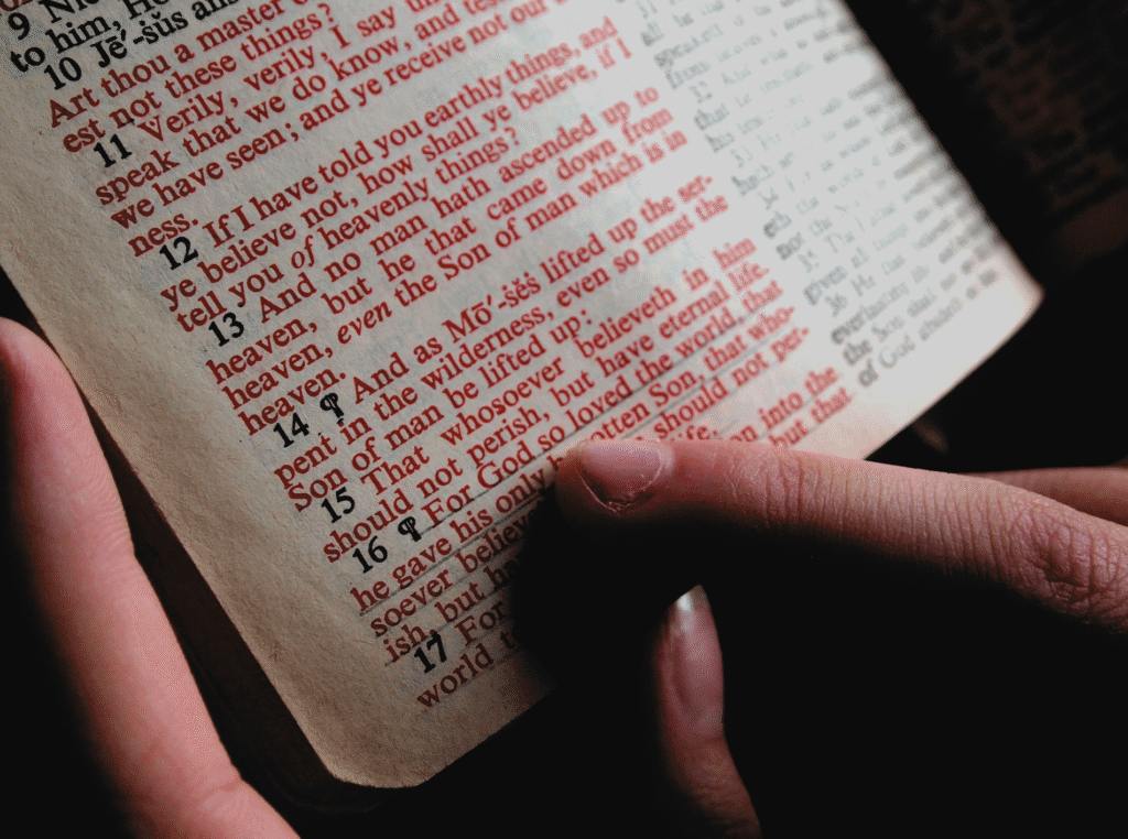 be a good person, close up of a passage in the new testiment bible with a woman's finger pointing to it.  I believe it's John 3:16 that it's highlighting.