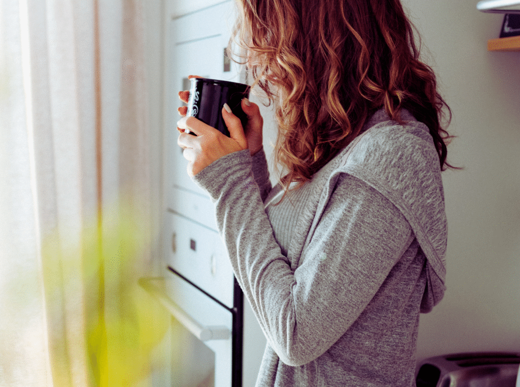 bible verses about hope. woman sipping a cup of coffee in her kitchen.