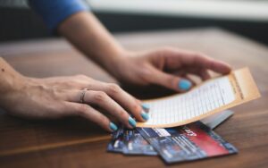 side hustle ideas. person reading card on three tickets