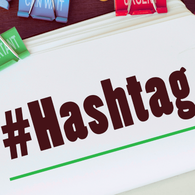 Do hashtags work on pinterest? picture of notbook with the word #Hashtag written on it and a couple clips above that say urgent and can wait.