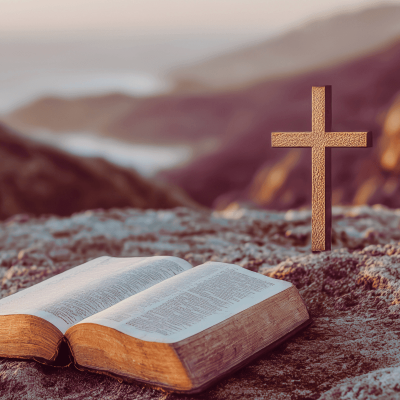 How to Give Yourself Grace. A picture of the outdoors with an open Bible and a cross in the background.