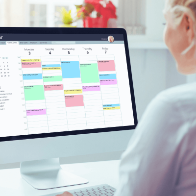 Schedule Pinterest Posts. woman looking at her computer and on the screen there is a digital calendar to schedul posts.