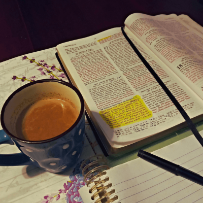 Best Biblical Evening Routine. theres a notebook and pen, an open Bible and a cup of cocoa sitting on a table ready for the evening routine.