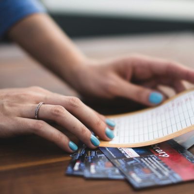 side hustle ideas. person reading card on three tickets