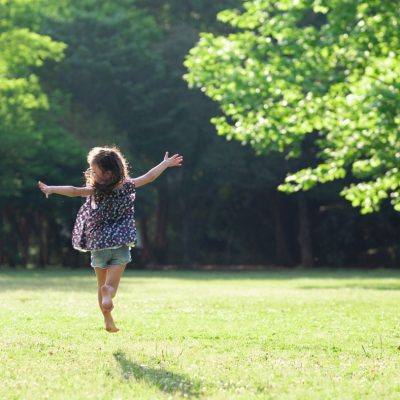 You Are Stronger Than You Think. Little Girl running in the field carefree with her arms out
