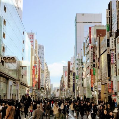 no one is too busy. people walking on street in between buildings under blue sky