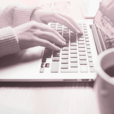 How to Make Money Online for Beginners. womans hands on keyboard with coffee to the side. it looks like she's typing away. showing she's working away trying her best to make money, but hasn't yet been successful.