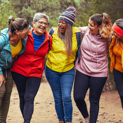 The magic of ordinary days. group of 5 women standing in a row with their arms interlocked laughing and having a good time. different ages, different races, different sizes.