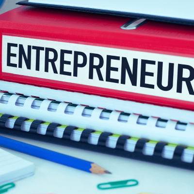 what is an entrepreneur. stack of books with one that says on the spine Entrepreneur. pencil next to the books