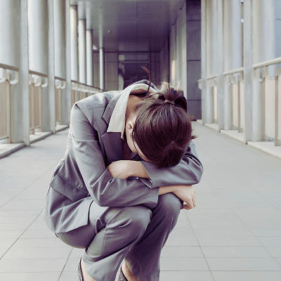 What to do when you feel helpless. woman kneeling on the floor in the hall of a courhouse with her head in her lap.